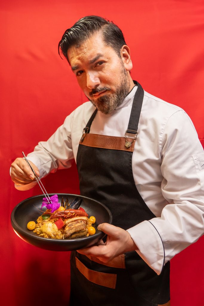 Chef con paella española fotografiado en estudio